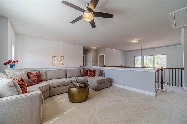 living area featuring attic access, carpet, baseboards, and ceiling fan