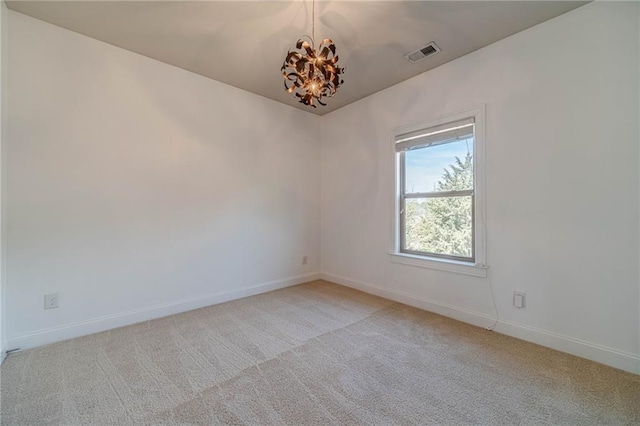 spare room with visible vents, light carpet, baseboards, and a chandelier