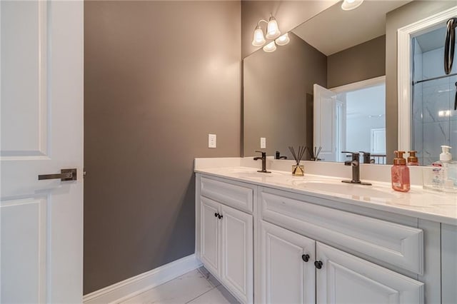 full bath with double vanity, baseboards, marble finish floor, and a sink