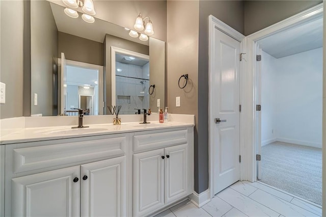 bathroom featuring double vanity, a shower, marble finish floor, and a sink