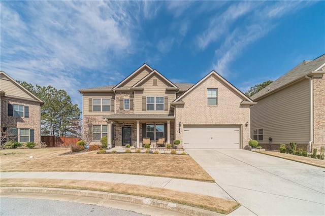 view of front of house featuring brick siding, covered porch, driveway, and an attached garage