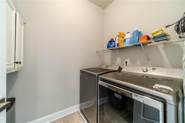 clothes washing area with tile patterned floors, cabinet space, baseboards, and washer and clothes dryer