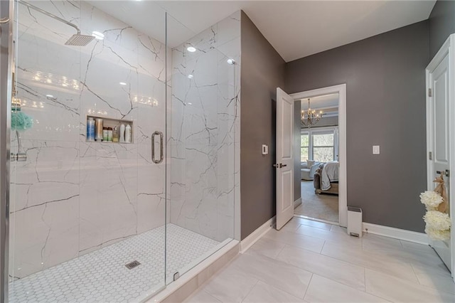 ensuite bathroom featuring a marble finish shower, a chandelier, connected bathroom, and baseboards