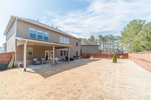 rear view of property with french doors, a patio, and a fenced backyard