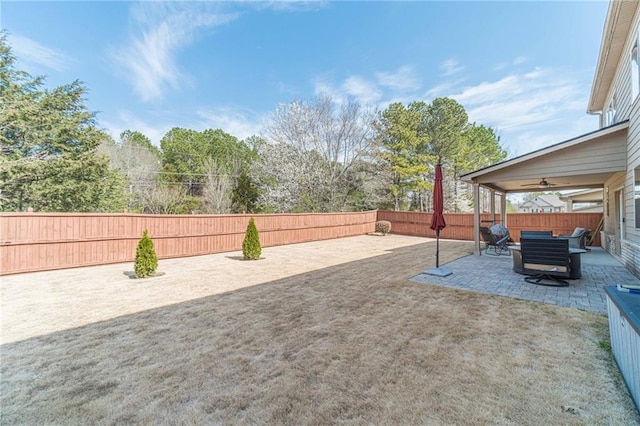 view of yard with a fenced backyard, a ceiling fan, and a patio area