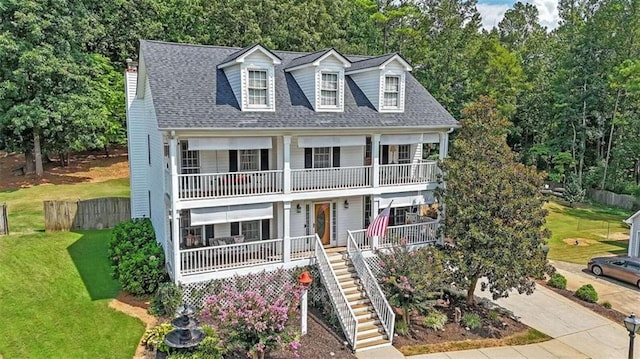 view of front facade with a balcony and a front yard