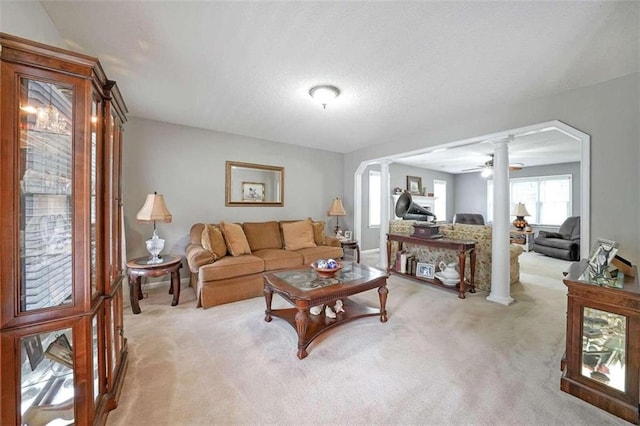 carpeted living room featuring ceiling fan and ornate columns