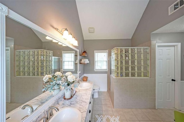 bathroom with lofted ceiling, double vanity, and tile patterned floors