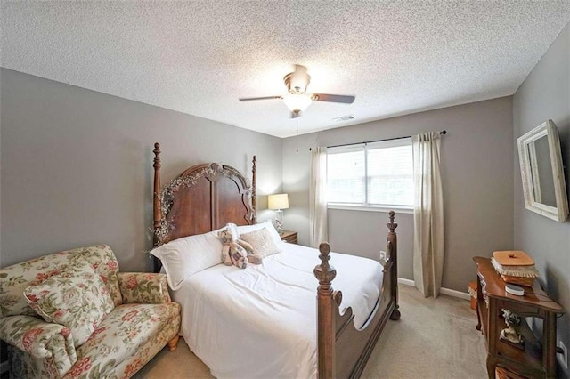 carpeted bedroom with ceiling fan and a textured ceiling