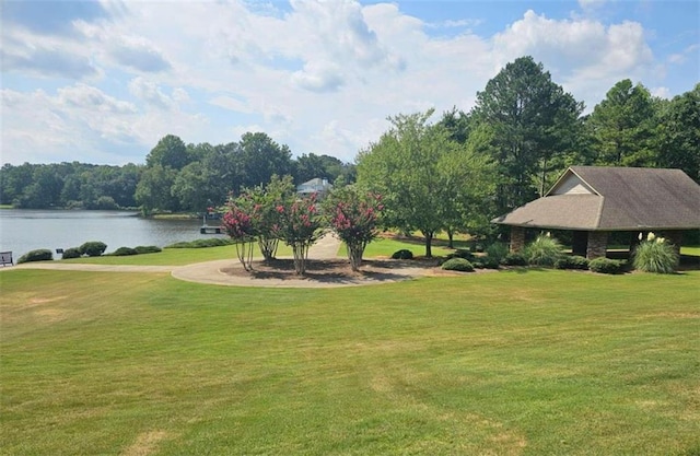 surrounding community with a yard and a water view