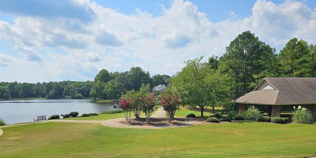 view of property's community with a lawn and a water view