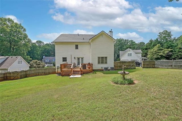 back of house featuring a lawn and a deck