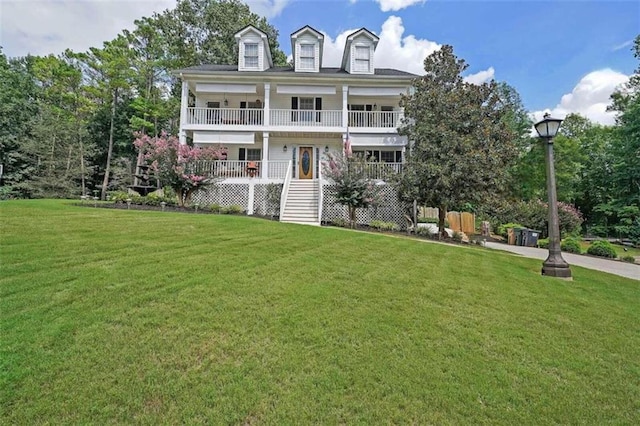 exterior space featuring a balcony and a front yard