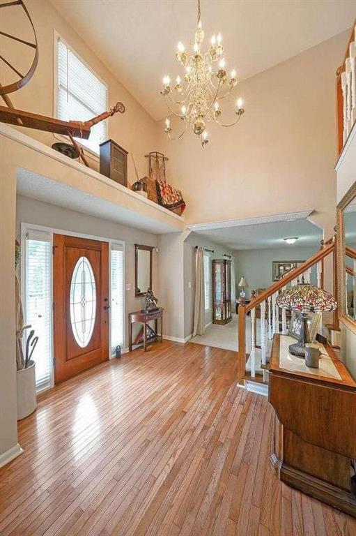 foyer entrance featuring high vaulted ceiling, light hardwood / wood-style flooring, and a chandelier