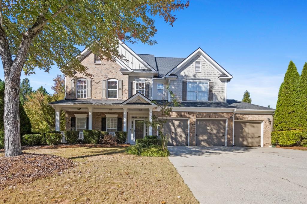 view of front of home with a garage, a front lawn, and a porch