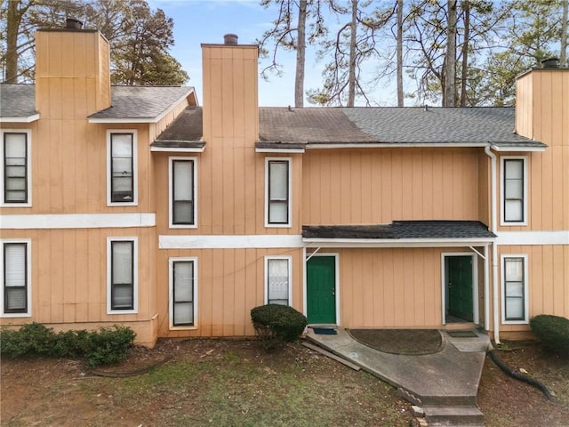 view of front of property with a shingled roof and a chimney