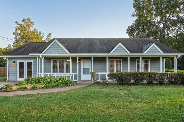 single story home with french doors, covered porch, and a front yard