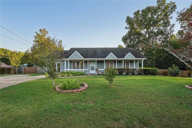 ranch-style home with a porch, fence, driveway, and a front lawn