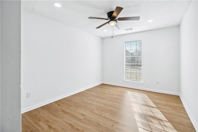 spare room featuring ceiling fan, light hardwood / wood-style floors, and a textured ceiling