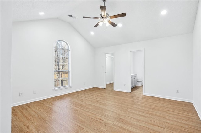 unfurnished bedroom with lofted ceiling, ensuite bath, a spacious closet, light hardwood / wood-style flooring, and ceiling fan