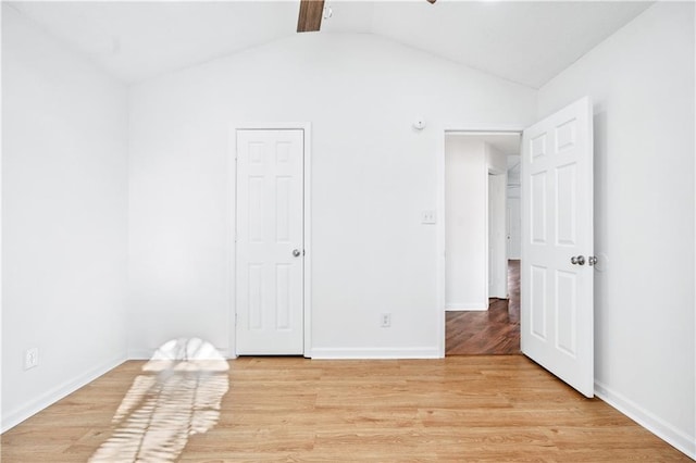 unfurnished bedroom featuring lofted ceiling and light hardwood / wood-style flooring