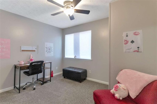 carpeted office space featuring baseboards, a textured ceiling, and ceiling fan