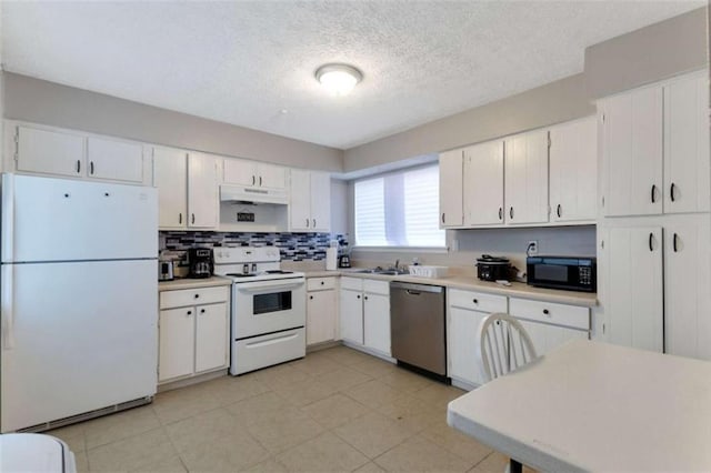 kitchen featuring under cabinet range hood, white appliances, white cabinetry, and light countertops