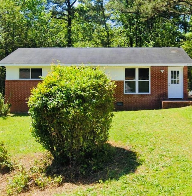 view of front facade with brick siding and a front lawn