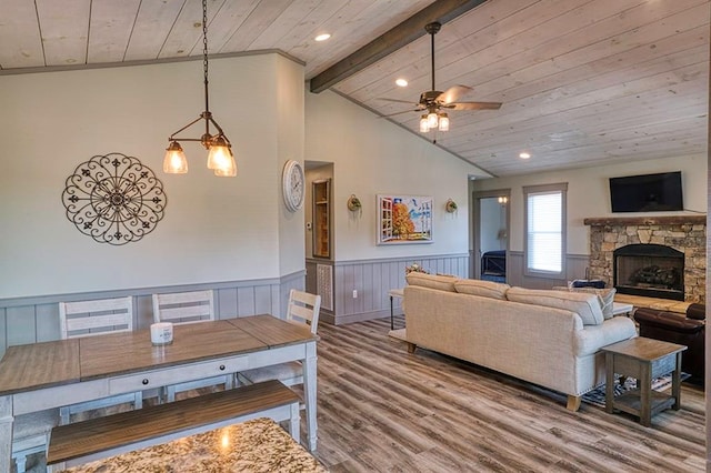 living room featuring wooden ceiling, ceiling fan, hardwood / wood-style flooring, and a stone fireplace