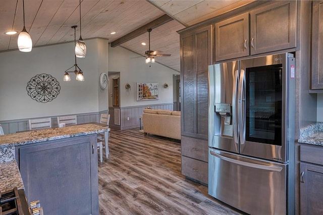 kitchen featuring stainless steel fridge, light stone counters, dark hardwood / wood-style flooring, ceiling fan, and decorative light fixtures