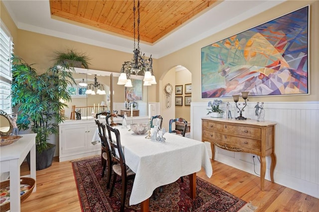 dining space featuring a chandelier, a tray ceiling, wooden ceiling, and light hardwood / wood-style flooring