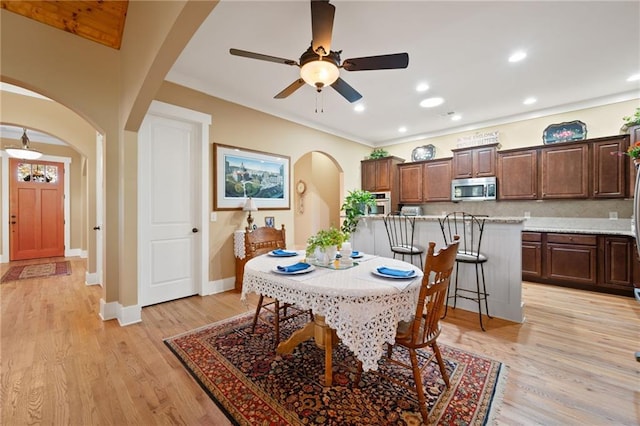 dining room featuring ceiling fan, crown molding, and light hardwood / wood-style floors