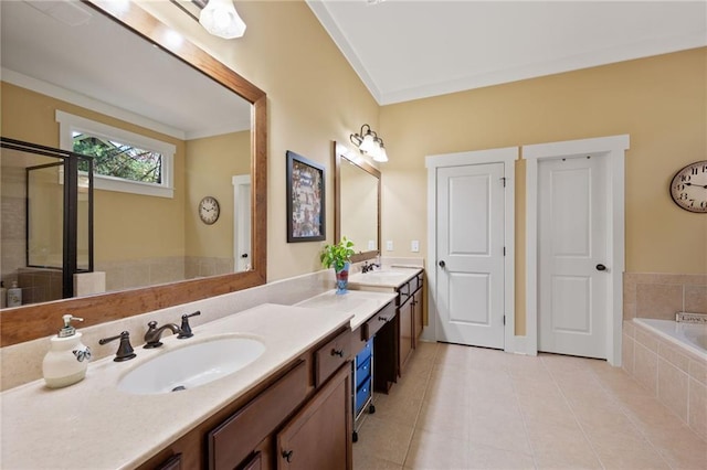 bathroom featuring double sink, tile floors, large vanity, and tiled tub