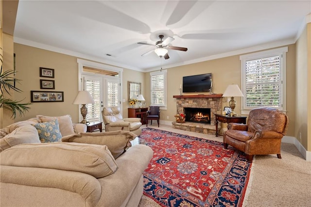 carpeted living room with ornamental molding, ceiling fan, and a fireplace