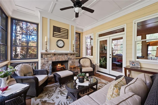 sunroom featuring french doors, a healthy amount of sunlight, a fireplace, and ceiling fan