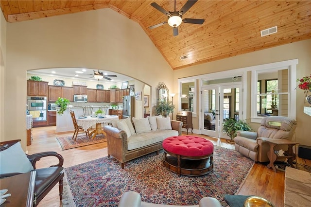 living room with high vaulted ceiling, ceiling fan, wooden ceiling, and light hardwood / wood-style flooring