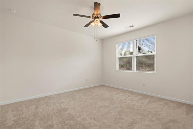 unfurnished room with baseboards, a ceiling fan, visible vents, and light colored carpet