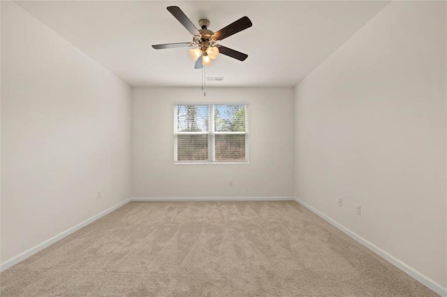 empty room featuring light carpet, ceiling fan, visible vents, and baseboards