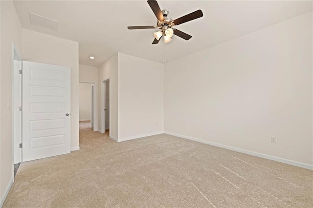 empty room with a ceiling fan, light carpet, and baseboards