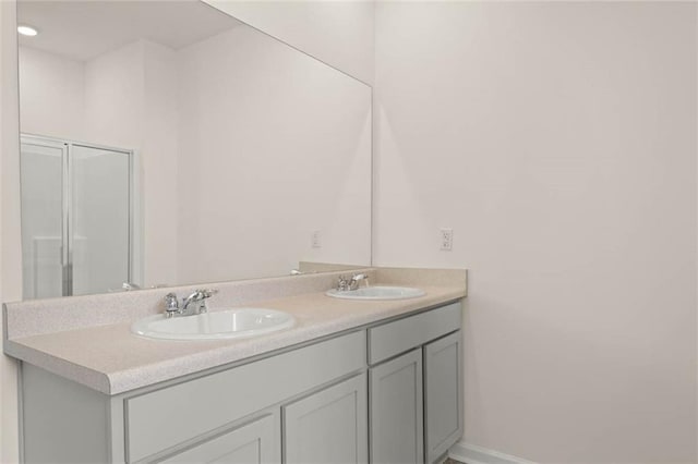 bathroom with double vanity, a sink, and baseboards