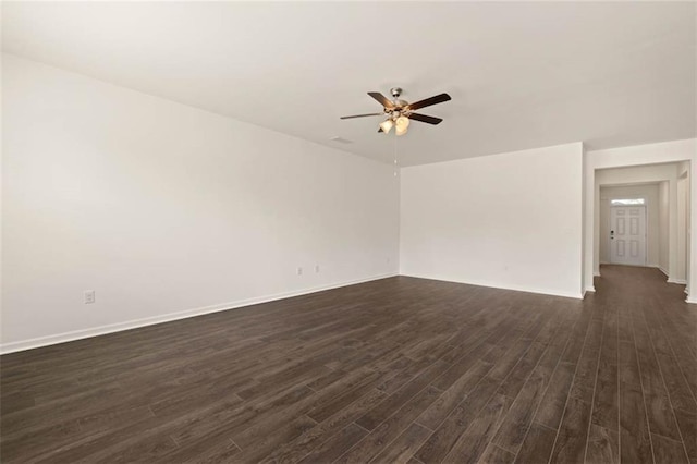 empty room with ceiling fan, baseboards, and dark wood-style flooring