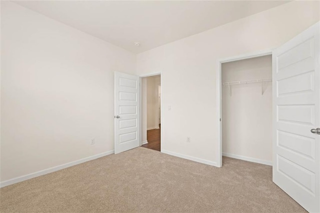 unfurnished bedroom with a closet, carpet flooring, and baseboards