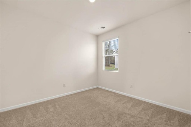 unfurnished room featuring carpet flooring, visible vents, and baseboards