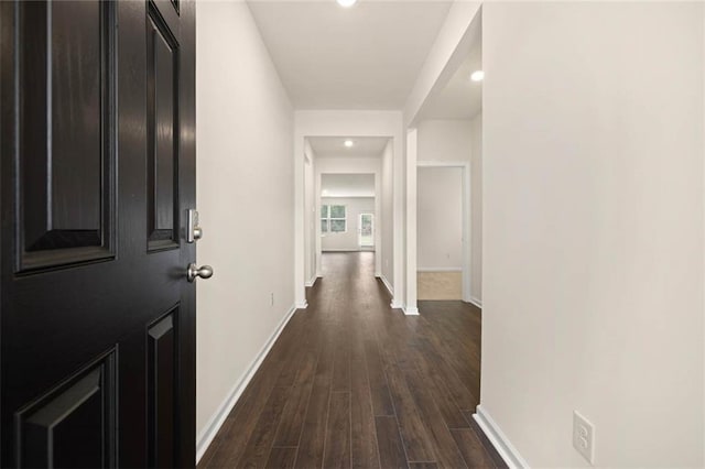 hallway with dark wood-style floors and baseboards