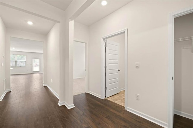 hallway featuring recessed lighting, dark wood-style flooring, and baseboards