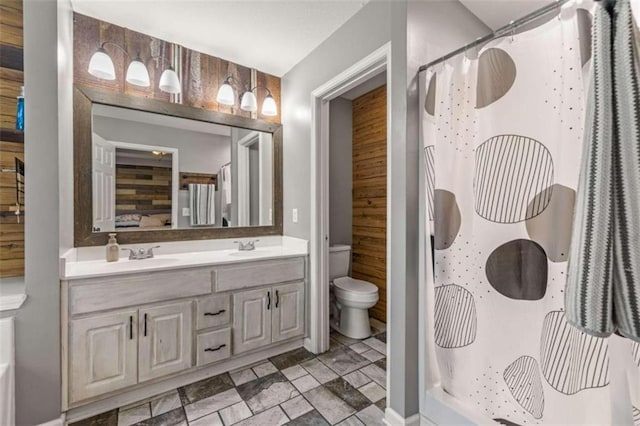 bathroom featuring vanity, wooden walls, toilet, and walk in shower