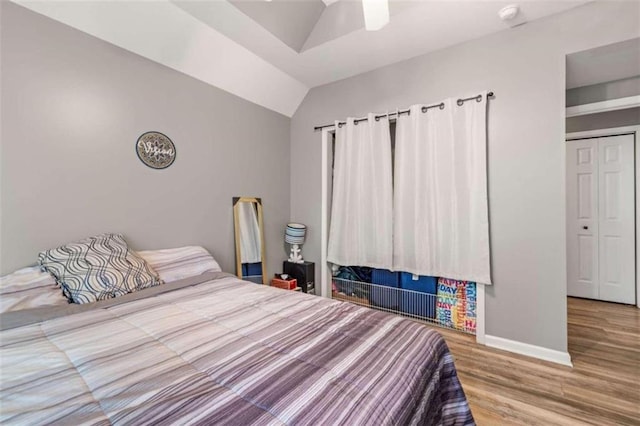 bedroom featuring hardwood / wood-style floors, ceiling fan, and lofted ceiling