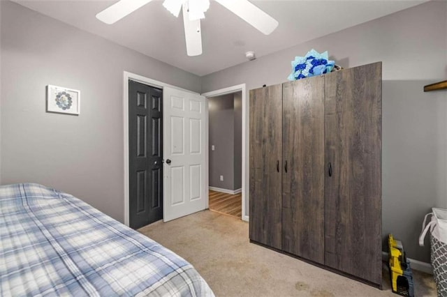 bedroom with ceiling fan, a closet, and light colored carpet