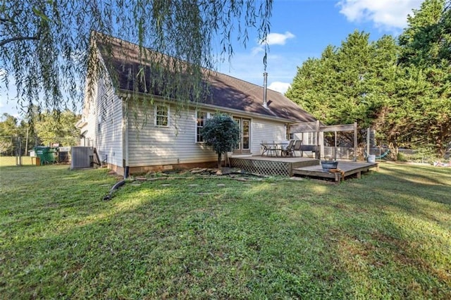 rear view of house with central air condition unit, a wooden deck, and a yard