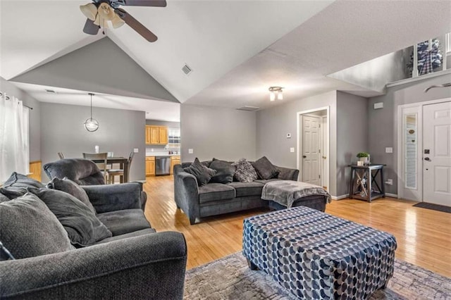 living room with light wood-type flooring, high vaulted ceiling, and ceiling fan